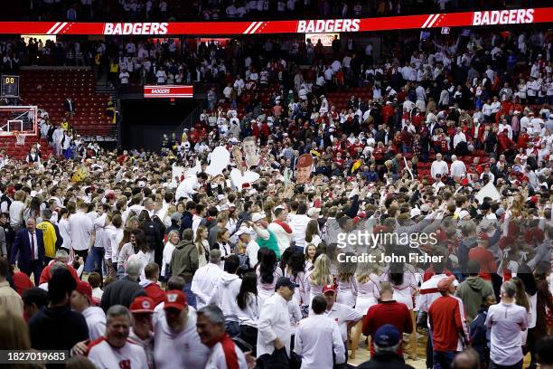Fans storm the court after the Wisconsin Badgers upset the Marquette Golden Eagles 75-64 at Kohl Center on December 02, 2023 in Madison, Wisconsin.