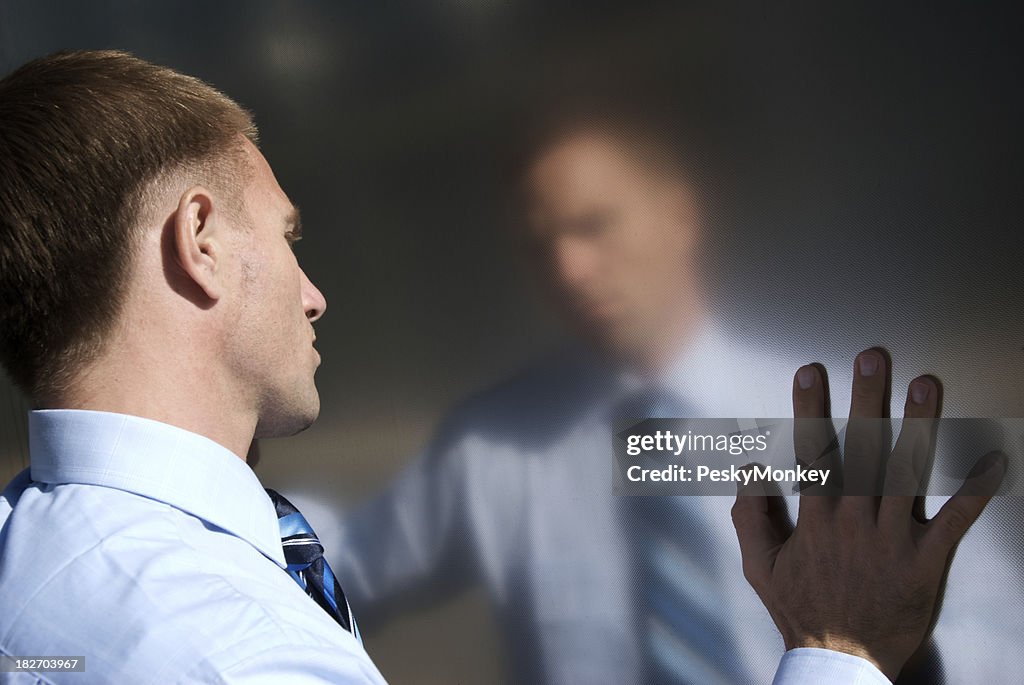 Pensive Businessman Stands Touching Reflection