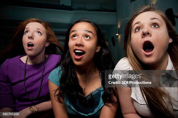 surprised women with mouths open watching a movie - outrage 2010 film stock pictures, royalty-free photos & images