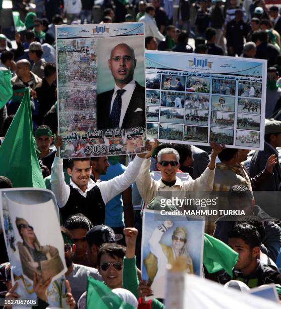Thousands of Libyans holding up banners and posters of their leader Moamer Kadhafi and his son Saif al-Islam gather in Tripoli's Green Square as they...