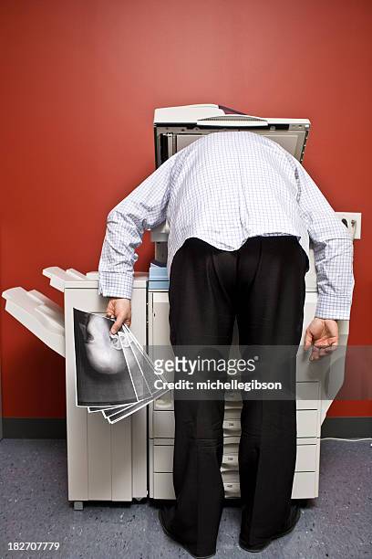 man bending over the photocopier to photocopy his face - boredom man stock pictures, royalty-free photos & images