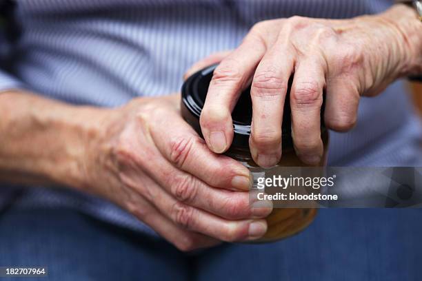 senior eröffnung einmachglas - arthritis hands stock-fotos und bilder