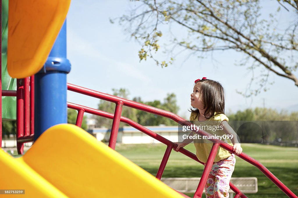 Cute girl going up the playground stairs