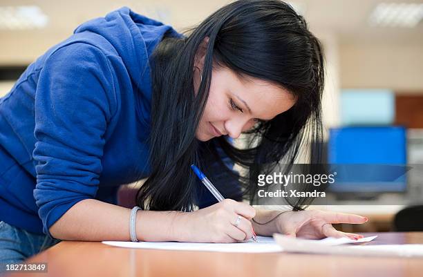 female student making notes on piece of paper - cute college girl stockfoto's en -beelden