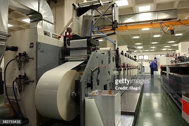 printing machine with roll of paper in factory - drukkerij stockfoto's en -beelden