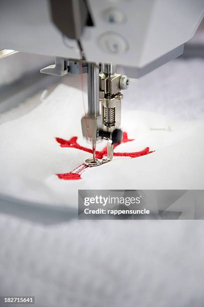 embroidering red crosses - embroidery stockfoto's en -beelden