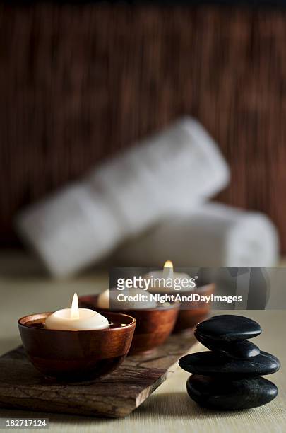 candles and massage stones in a zen spa background - essence day stock pictures, royalty-free photos & images