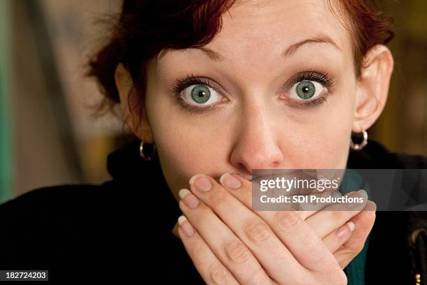 surprised young woman with hands over her mouth - hand covering face stock pictures, royalty-free photos & images