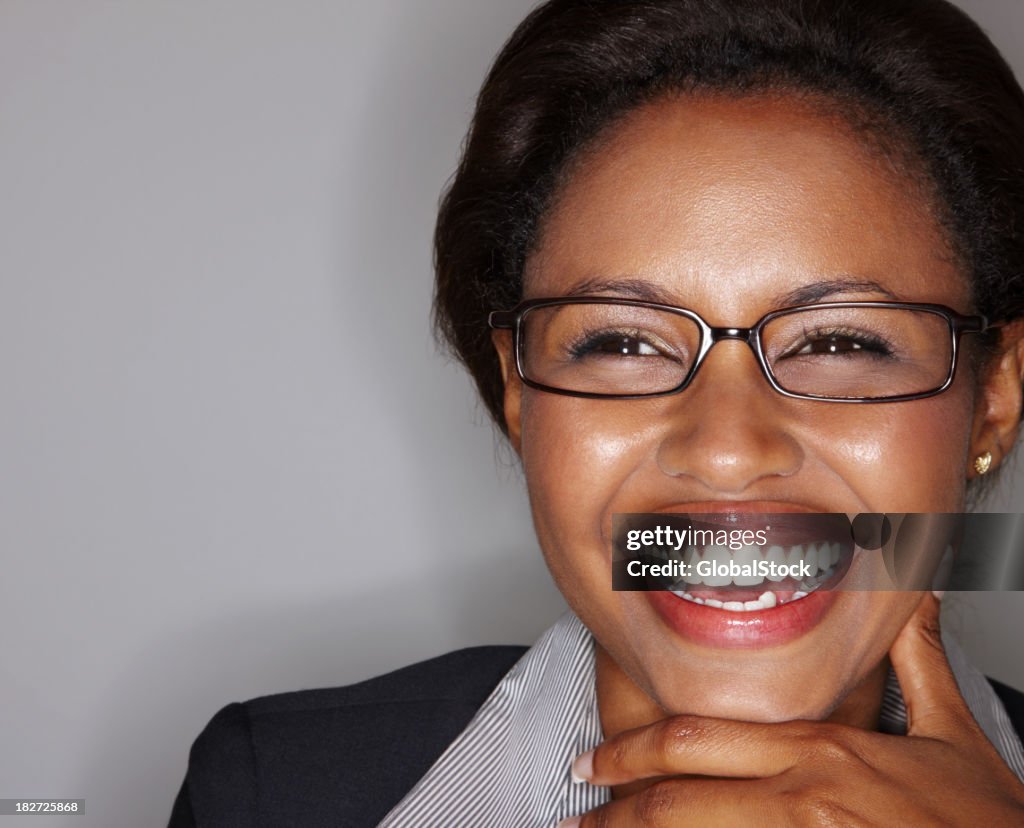 Close-up of a young business woman laughing against gray