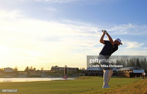 Scottie Scheffler of the United States hits his approach shot on the 18th hole during the third round of the Hero World Challenge at Albany Golf...