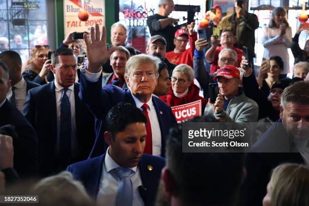 Republican presidential candidate former President Donald Trump greets guests as he arrives at a commit to caucus campaign event at the Whiskey River...