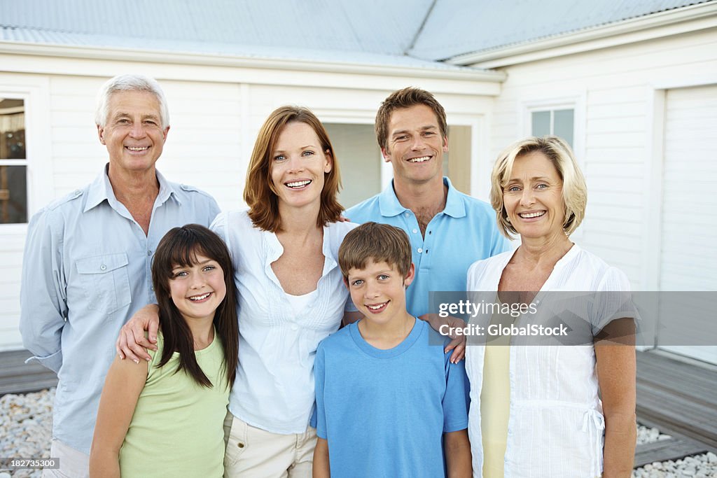 Sonriente familia tres general de pie juntos al aire libre