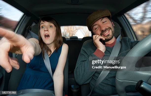 a distracted driver ignoring his passenger's warning - distracted driving stock pictures, royalty-free photos & images