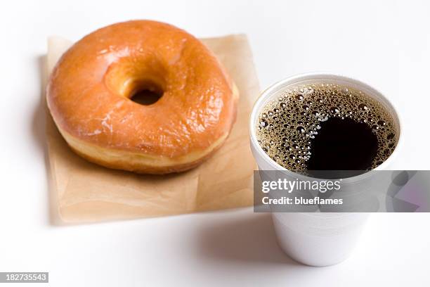 close-up of a cup of black coffee and a glazed donut - donut stock pictures, royalty-free photos & images