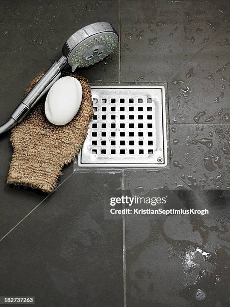 wet bathroom with bathing utensils on the floor - riool stockfoto's en -beelden