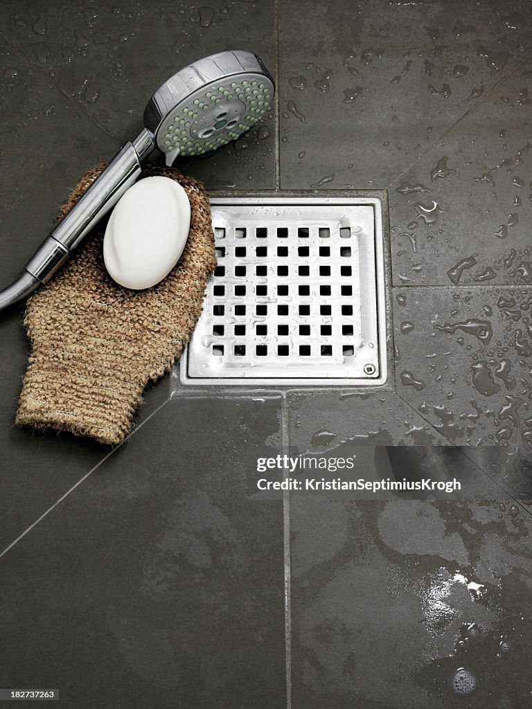 Wet bathroom with bathing utensils on the floor