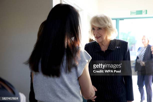 Queen Camilla speaks to women as she visits the Ashiana women's refuge on December 6, 2023 in London, England.
