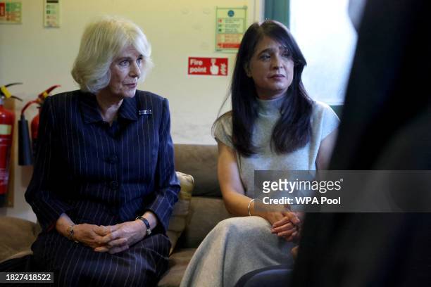 Queen Camilla sits next to Director of Ashiana, Shaminder Ubhi as she speaks to women as she visits the Ashiana women's refuge on December 6, 2023 in...