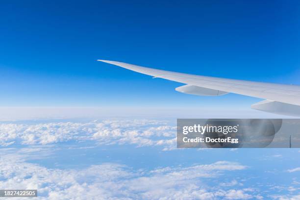 wing of thai airways aircrafts tg 676 from bkk - nrt with blue sky - airplane wing stock pictures, royalty-free photos & images