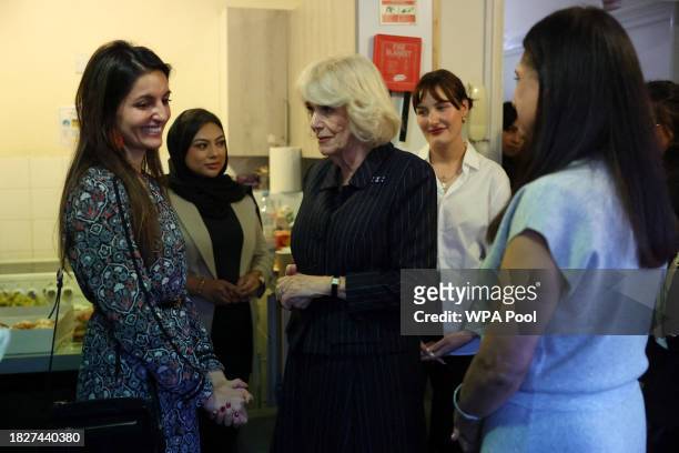 Queen Camilla speaks to women as she visits the Ashiana women's refuge, while Director of Ashiana, Shaminder Ubhi looks on on December 6, 2023 in...