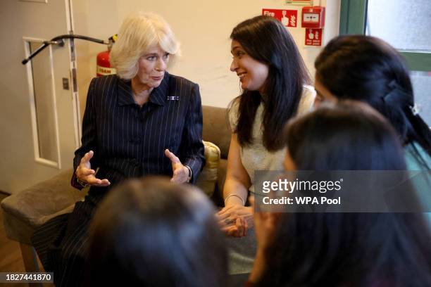 Queen Camilla speaks to women as she visits the Ashiana women's refuge on December 6, 2023 in London, England.