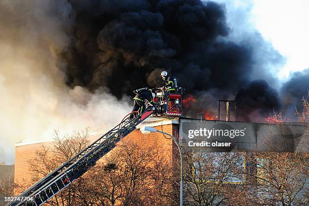 firemen on ladder fighting fire - extinguishing stock pictures, royalty-free photos & images