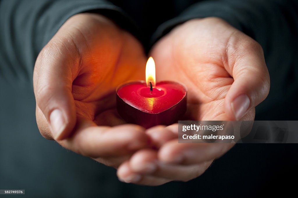 Heart-shaped candle in her hands