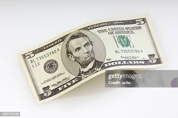 bent five dollar bill - us paper currency stockfoto's en -beelden