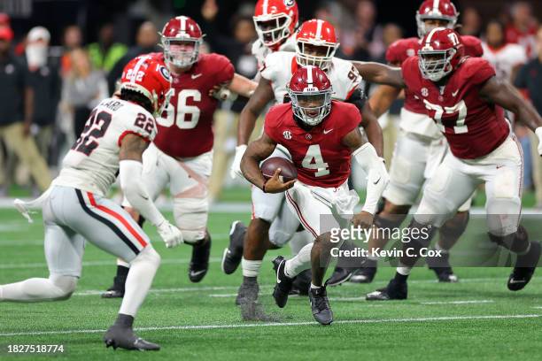 Jalen Milroe of the Alabama Crimson Tide rushes out of the pocket against Javon Bullard of the Georgia Bulldogs during the fourth quarter in the SEC...