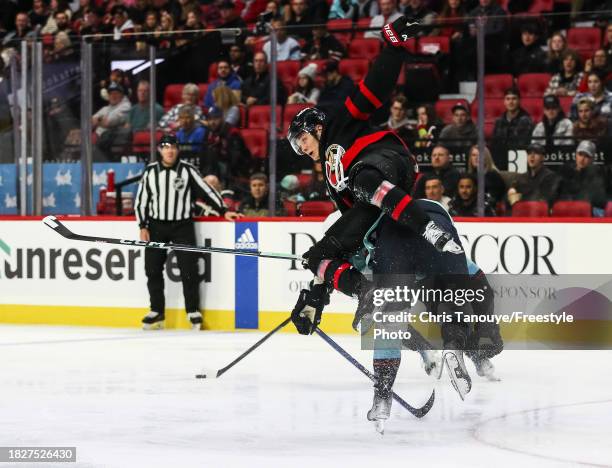 Justin Schultz of the Seattle Kraken collides with Tim Stützle of the Ottawa Senators during the second period at Canadian Tire Centre on December...