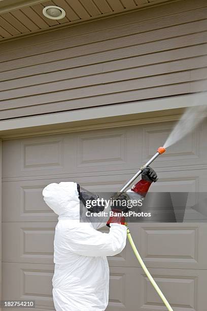 pest control worker spraying insecticide on a home’s garage - killing insects stock pictures, royalty-free photos & images