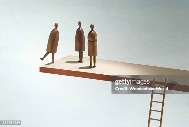 wooden figures on the edge of a wooden shelf with ladder - leading edge stock pictures, royalty-free photos & images