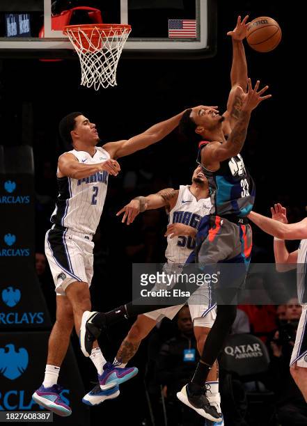Nic Claxton of the Brooklyn Nets grabs the rebound as Caleb Houstan and Cole Anthony of the Orlando Magic defend during the second half at Barclays...