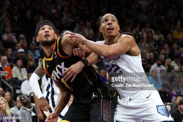 Devin Booker of the Phoenix Suns and Desmond Bane of the Memphis Grizzlies go for a rebound during the second quarter at Footprint Center on December...
