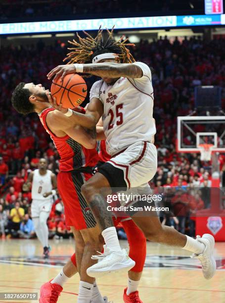 Clarence "Monzy" Jackson of the New Mexico State Aggies drives against Jaelen House of the New Mexico Lobos during the first half of their game at...