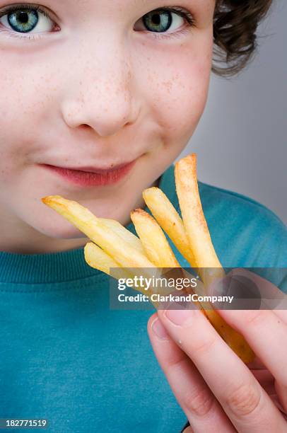 young boy eating chips - french fries stock pictures, royalty-free photos & images
