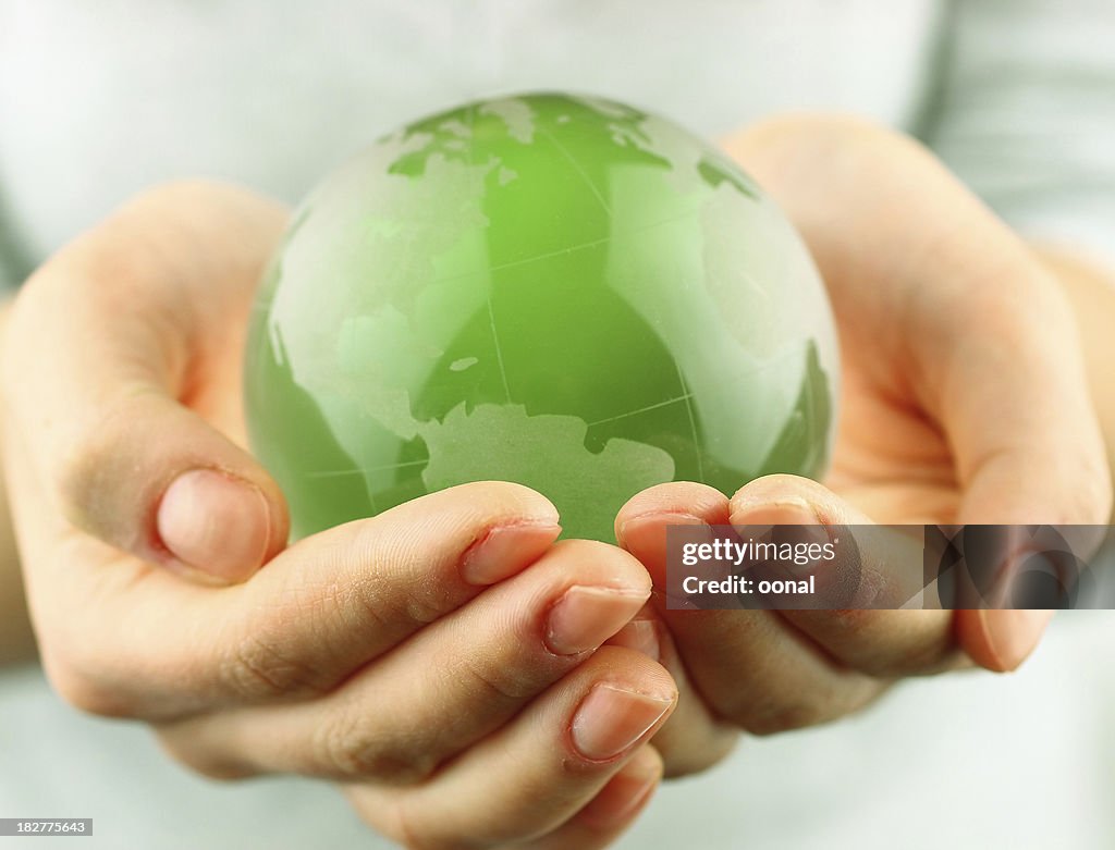 Small green globe in two cupped hands