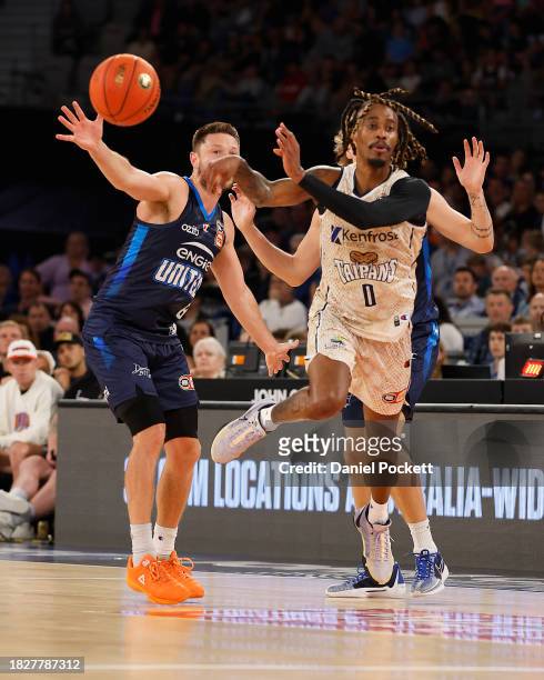 Tahjere McCall of the Taipans passes the ball under pressure from Matthew Dellavedova of United and Luke Travers of United during the round nine NBL...