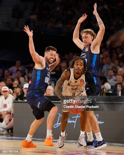 Tahjere McCall of the Taipans looks to pass the ball under pressure from Matthew Dellavedova of United and Luke Travers of United during the round...