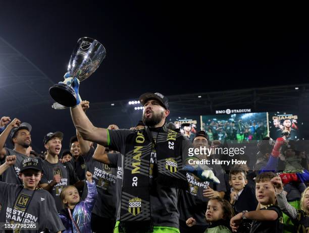 Maxime Crépeau of Los Angeles FC holds up the trophy, surrounded by teammates, in celebration of a 2-0 win over the Houston Dynamo in the Western...