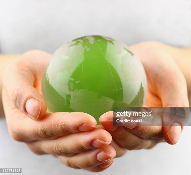 green globe in  hands - climate finance stock pictures, royalty-free photos & images