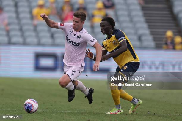 Connor Chapman of Melbourne Victory competes for the ball with Jing Machar Reec of the Mariners during the A-League Men round six match between...