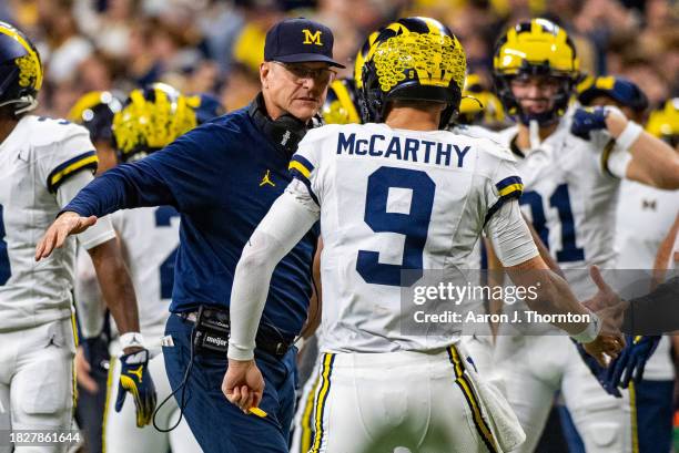 Head Football Coach Jim Harbaugh and J.J. McCarthy of the Michigan Wolverines celebrate after a play during the second half of the Big Ten...