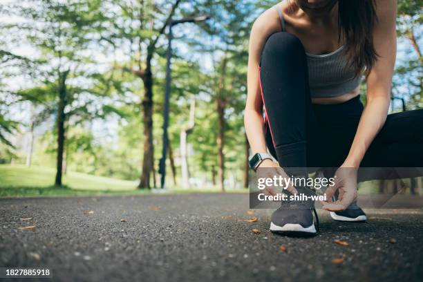 a young woman runner is outside in the morning, - joggeuse parc photos et images de collection