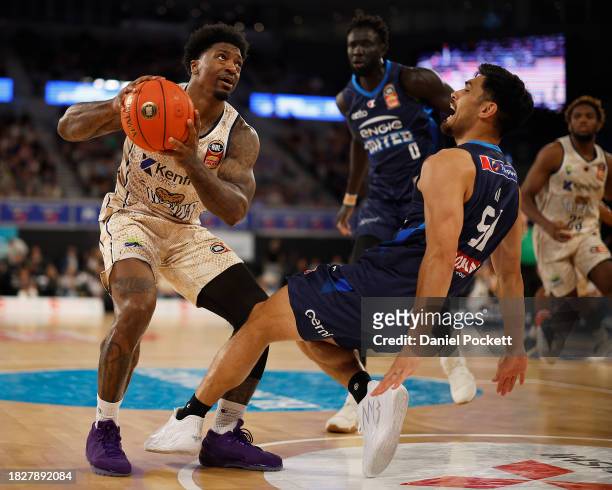 Patrick Miller of the Taipans drives to the basket under pressure from Shea Ili of United during the round nine NBL match between Melbourne United...