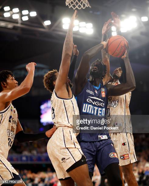 Jo Lual-Acuil Jr of United attempts to shoot under pressure from Josh Roberts of the Taipans and Tahjere McCall of the Taipans during the round nine...