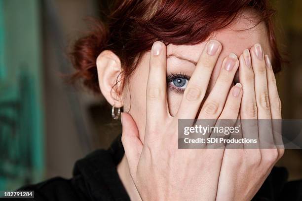 frau spähen durch ihre hände - spähen stock-fotos und bilder
