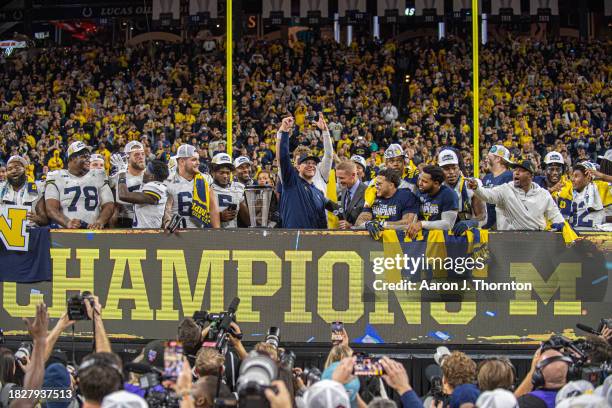 Head Football Coach Jim Harbaugh of the Michigan Wolverines celebrates with his team after winning the Big Ten Championship against the Iowa Hawkeyes...