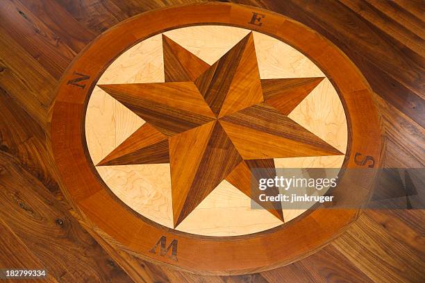 compass inlay in a hardwood floor. - inlegwerk stockfoto's en -beelden