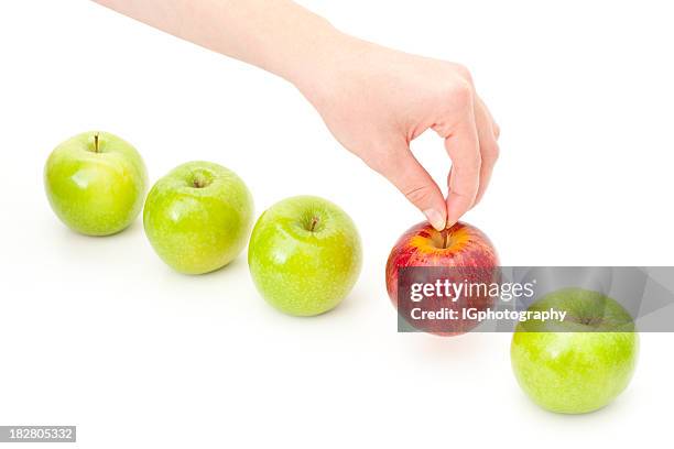 hand picking apple from row to illustrate choice and decision - red delicious stockfoto's en -beelden